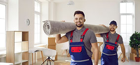 Movers carrying a rolled carpet